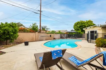 Private backyard pool with fenced deck and lounge chairs